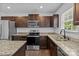 Kitchen featuring stainless steel appliances, dark cabinets, granite countertops, and a stainless steel sink at 2021 Tarzi Ln, Charlotte, NC 28215