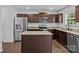 Kitchen featuring stainless steel appliances, dark cabinets, granite countertops, and a center island at 2021 Tarzi Ln, Charlotte, NC 28215