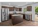 Kitchen featuring stainless steel appliances, dark cabinets, granite countertops, and a center island at 2021 Tarzi Ln, Charlotte, NC 28215