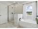 Clean, bright bathroom with a glass shower, soaking tub, and modern fixtures, illuminated by natural light at 203 Balboa St, Matthews, NC 28104