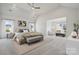 Bright and open bedroom with comfortable bed, bench, and windows, leading into a cozy living area at 203 Balboa St, Matthews, NC 28104
