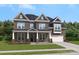 Charming two-story brick home with a well-manicured lawn, elegant dormers, and attached garage at 203 Balboa St, Matthews, NC 28104