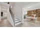 Inviting foyer with a staircase, view of living room, and office entrance with built-in shelving at 203 Balboa St, Matthews, NC 28104