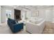 Open living room features a stone fireplace, beamed ceilings, and an inviting white sofa with blue armchairs at 203 Balboa St, Matthews, NC 28104