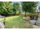 Expansive backyard with a stone patio, outdoor kitchen area, and a hammock, perfect for outdoor entertaining at 2206 Waters Trail Dr, Charlotte, NC 28216