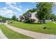 Landscaped lawn showcases a charming two-story home with lush greenery and a sidewalk at 2206 Waters Trail Dr, Charlotte, NC 28216