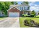 Charming two-story home with a brick accent, green shutters, well-manicured lawn, and a welcoming flower bed at 2206 Waters Trail Dr, Charlotte, NC 28216