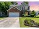 Charming two-story home with a brick accent, green shutters, well-manicured lawn, and a welcoming flower bed at 2206 Waters Trail Dr, Charlotte, NC 28216