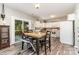 Open floor plan showcasing kitchen and dining area with white cabinets, wooden table and view to backyard at 2206 Waters Trail Dr, Charlotte, NC 28216