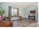 Bright living room featuring hardwood floors, a large window, complemented by elegant decor and neutral wall paint at 2206 Waters Trail Dr, Charlotte, NC 28216