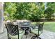 Cozy outdoor dining set on a stone patio in a lush backyard with mature trees at 2206 Waters Trail Dr, Charlotte, NC 28216