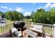 Outdoor deck with a grill and patio furniture overlooking a peaceful green landscape and blue sky at 2217 Goldwood Dr, Charlotte, NC 28215