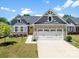 Charming home featuring stone accents, a two-car garage, and a well-manicured lawn on a sunny day at 2217 Goldwood Dr, Charlotte, NC 28215