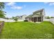 Wide view of the fenced backyard showing the lawn, patio, hot tub, and the home's screened porch at 3053 Riker St, Clover, SC 29710