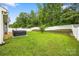 Spacious fenced backyard featuring green grass, a hot tub, and mature trees for privacy at 3053 Riker St, Clover, SC 29710