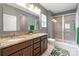 Modern bathroom featuring double sinks, granite countertops, and a glass-enclosed shower create a luxurious feel at 3053 Riker St, Clover, SC 29710