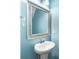 Charming half-bathroom with a pedestal sink and framed mirror, illuminated by modern lighting at 3053 Riker St, Clover, SC 29710