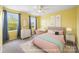 Bright bedroom with yellow walls, a ceiling fan, and two windows provides a cheerful and comfortable retreat at 3053 Riker St, Clover, SC 29710