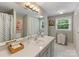 Well-lit bathroom with a spacious vanity, large mirror, and ample storage at 3225 Mill Pond Rd, Charlotte, NC 28226