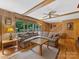 Inviting living room with beamed ceilings, wood paneled walls, large windows, and hardwood floors at 3225 Mill Pond Rd, Charlotte, NC 28226