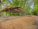 Covered pavilion with picnic tables and a swing set in a wooded park area, ideal for outdoor gatherings at 3225 Mill Pond Rd, Charlotte, NC 28226