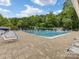 Community pool featuring multiple swimming lanes, lounge chairs, umbrellas, and blue and yellow decor at 3225 Mill Pond Rd, Charlotte, NC 28226