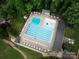 Aerial view of community pool with lounge chairs, tables, and diving area surrounded by trees at 3225 Mill Pond Rd, Charlotte, NC 28226