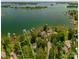 Aerial view of a lakefront property with a lush landscape and a private dock on a sunny day at 3248 Lake Shore S Rd, Denver, NC 28037