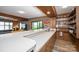 Basement bar area features a long counter, exposed brick, wood shelving, and easy lake views at 3248 Lake Shore S Rd, Denver, NC 28037