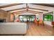 Spacious living area with a brick fireplace, wood beam ceiling, and large windows overlooking the lake at 3248 Lake Shore S Rd, Denver, NC 28037