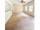 Empty living room featuring neutral walls, carpet flooring, and two windows for lots of natural light at 3430 Fincher Blvd, Charlotte, NC 28269