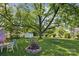 Spacious backyard featuring a mature shade tree, fire pit, and ample lawn at 3721 Conway Ave, Charlotte, NC 28209