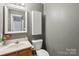 Well-lit half bathroom with modern fixtures, vanity, and convenient toilet placement at 3721 Conway Ave, Charlotte, NC 28209