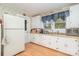 Kitchen includes white cabinets, wood floors, and a double sink at 4059 10Th Avenue Sw Dr, Hickory, NC 28602