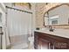 Bright bathroom featuring a dark wood vanity, a framed mirror, and a shower tub with a white shower curtain at 454 N Eastway Dr, Troutman, NC 28166