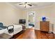 Bedroom with hardwood floors, a bed, a TV, a dresser, and an open door leading to another bedroom at 454 N Eastway Dr, Troutman, NC 28166