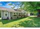 Charming home featuring well-kept lawn, stone accents, flower boxes, and a relaxing bench under a shade tree at 454 N Eastway Dr, Troutman, NC 28166