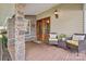 Inviting front porch featuring a double door entrance, stone pillar accents, and stylish outdoor seating at 454 N Eastway Dr, Troutman, NC 28166