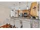 Open kitchen with brick accent wall, breakfast bar, stainless steel appliances, and wooden cabinets at 454 N Eastway Dr, Troutman, NC 28166
