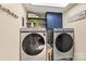A laundry room featuring a washer and dryer, a shelf with decorations, and storage cabinets at 454 N Eastway Dr, Troutman, NC 28166