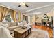 Cozy living room featuring a plush sectional sofa, hardwood floors, a stone fireplace, and natural light at 454 N Eastway Dr, Troutman, NC 28166