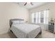 A bright bedroom with a ceiling fan, a gray padded headboard, and natural light from the windows at 5079 Skyfest Dr, Charlotte, NC 28215