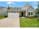 Charming home with a well-manicured lawn and a two-car garage, showcased on a sunny day at 5079 Skyfest Dr, Charlotte, NC 28215