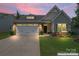 Charming home with a well-manicured lawn and a two-car garage, showcased at twilight at 5079 Skyfest Dr, Charlotte, NC 28215