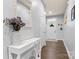 Bright hallway with hardwood floors, a decorative mirror, and a view of the front door at 5079 Skyfest Dr, Charlotte, NC 28215