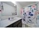 Bathroom featuring a white sink, wood cabinets, and a shower with a colorful curtain at 5125 Thomasville Dr, Belmont, NC 28012