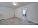 Empty bedroom showcasing neutral walls, carpeting, and a view into a connecting room at 5125 Thomasville Dr, Belmont, NC 28012