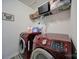 Laundry room with red washer and dryer, wire shelving, and decor at 5125 Thomasville Dr, Belmont, NC 28012
