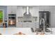 Updated kitchen boasts stainless steel appliances, a modern range hood, and sleek white cabinets at 5317 Black Oak Ln # 11, Waxhaw, NC 28173