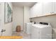 Bright laundry room featuring white washer and dryer units with upper cabinets at 5655 Arnold Way, Mount Pleasant, NC 28025